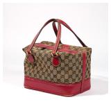 LOT 493 | EARLY GUCCI TRAIN BAG | Patterned fabric with read leather trim and brass hardware h. 8 w.