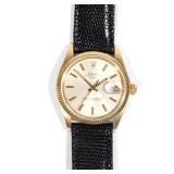  Silver face with gold and black baton numerals, cyclops date window, faceted gold bezel, lugs with 