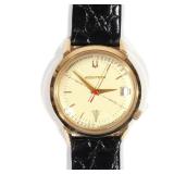  Gold dial with gold baton numerals, date window, sweep seconds hand, "initio" reference line and he