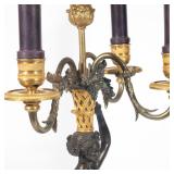 bronze female figure carrying a basket-form three-arm candelabra overhead, on a marble and ormolu ba