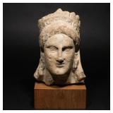 Lot 185  |  CYPRIOT LIMESTONE HEAD OF A GODDESS  |  Circa 3rd-2nd century, B.C., the head turned sli