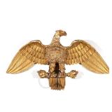 GILT CARVED EAGLE WALL PLAQUE | 19th century, with spread wings, mounted on baton with flame ends an