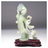 CHINESE QING DYNASTY PALE CELADON JADE GUANYIN | Quan Yin, on a conforming carved wood stand. h. 8 w