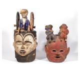 (2PC) IGBO HELMET MASKS | Nigeria, both surmounted by humanoid figures, one with a wheel-shaped crow