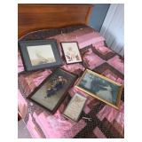 Queen size bed, pink and black comforter, pictures and assorted framed art