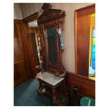 Victorian Eastlake hall tree featuring walnut wood, a marble top console, and a mirror.