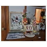 Group of holiday-themed decorative signs and ornaments featuring snowmen and Christmas motifs