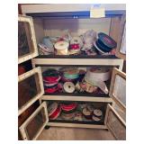 Plastic storage cabinet with three shelves containing various spools of ribbon; measures 25 x 14 x 3
