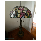 Tiffany-style table lamp with multicolor stained slag glass floral shade with a heavy metal base, an