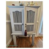 White wooden cabinet with slatted doors and interior wine rack; measures 30" x 47" x 17" 