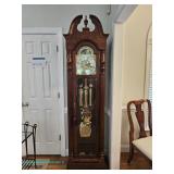 Ridgeway grandfather clock with ornate brass dial and pendulum, in working condition. Must restart t