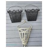 Assorted metal wall pocket baskets including black wire hanging baskets with arched handles and a cr