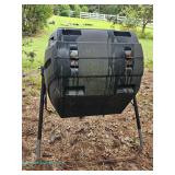 Black plastic compost tumbler with metal stand; measures 26" x 44" x 32"
