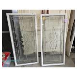 Two decorative glass window panels with white frames and geometric designs; measures 24" x 50"