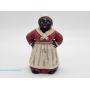Black Americana-style painted figural coin bank depicting a woman in red dress, white apron, and hea