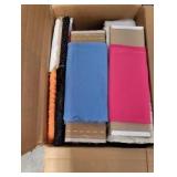 A box of various rolls of fabric for sewing and crafts
