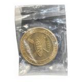 Gold-tone commemorative coin in plastic bag