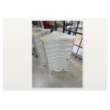 Stack of White Plastic Chairs