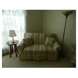 Cream color love seat with stripes of blue and maroon