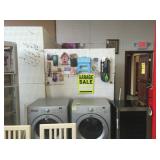 Various household items hang on the wall including compact step stool, bib apron, garage sale signs