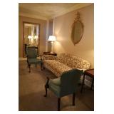 upholstered couch, leather armchairs, carved wood mirrors, glass lamps
