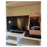 This lot contains a Samsung 40" TV, DVD/VHS player and associated cables, plugs and Netgear router. 