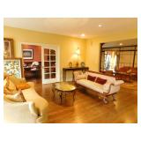 Formal living room with formal sofa, bonus sofa, smoke mirrored coffee table and sofa table with art