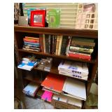 Mahogany book shelf loaded with books and office supplies 