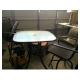 Bar-height glass-top patio table and matching chairs
