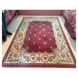 Large Rose Fleur De lis Rug. There are bumps and impressions where furniture was previously.