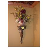 Artificial floral arrangement on sconce shelf