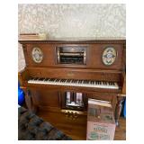 Vintage player piano with a box of rolls of music