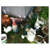 Garden gnomes and outdoor decor. The shed contains a few garden tools.