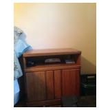 Oak TV stand being used as a nightstand.