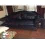 Black leather sofa with wood accents