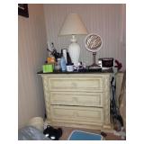 Stone-topped three-drawer nightstand and lamp.