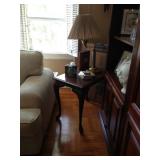 End table with cabriole legs and swing-arm lamp.