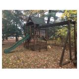 Playground set with swings, slide and playhouse.