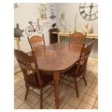 OVAL DINING TABLE WITH 4 CHAIRS (AN EXTENSION LEAF IS LEANING AGAINST THE WALL IN BACKGROUND)