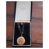 JEWELRY - GOLD BROACH W/ INSET BLUE STONES ON A RIBBON FOR USE AS A NESCKLACE IN A JW Bader JEWELER 