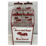 Gordon’s Red Wire Display Rack with Four Glass Jars and a Contemporary Sign