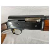 with detailed engraving, a ventilated rib barrel, and a checkered walnut stock and forearm