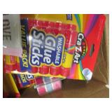 box of mostly packages of glue stic...