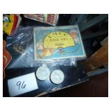 misc collection of vintage items, cardboard serving plate, hair nets, toothpick angels for cake decorating I assume, old sunbeam iron box, slide rule, baby shoes, and a mustimeter