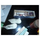 misc collection of vintage items, cardboard serving plate, hair nets, toothpick angels for cake decorating I assume, old sunbeam iron box, slide rule, baby shoes, and a mustimeter