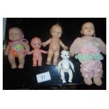 group of vintage dolls, far left is a berenger, 3 kewpies, one is ceramic/porcelain connected with string, all moveable joints