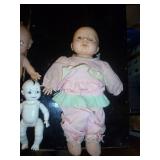 group of vintage dolls, far left is a berenger, 3 kewpies, one is ceramic/porcelain connected with string, all moveable joints