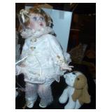 New in box porcelain doll with her dog pulling on her dress, another porcelain doll and a bear with lace dress