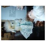 New in box porcelain doll with her dog pulling on her dress, another porcelain doll and a bear with lace dress
