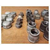 Lot of (39) Steel Pipe Fittings - (11) 1-1/4" Couplers, (2) 1-1/4" Unions, (6) 1-1/4" x 1" Reducers, (2) 1-1/4" x 1/2" Reducers, (5) 1-1/4" Plugs, (9) 1-1/4" Caps, (4) 1-1/2" Plugs